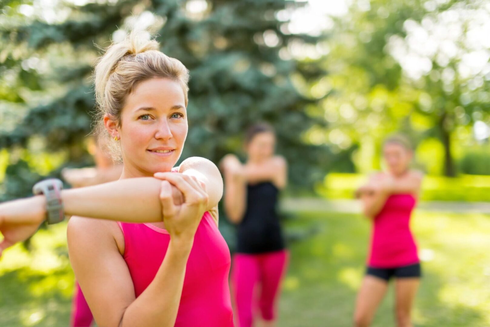 A woman in pink shirt holding a baseball bat.