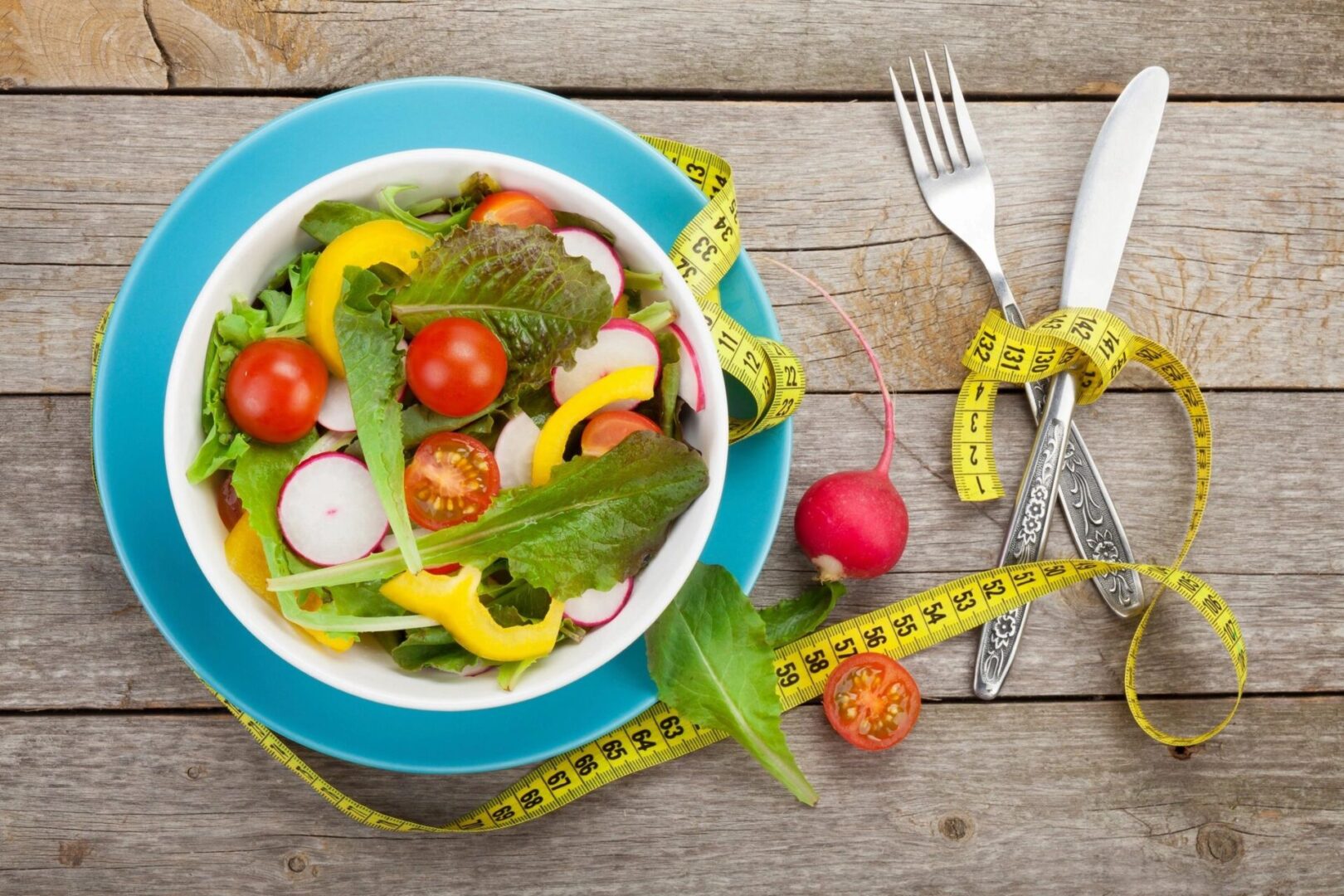 A bowl of salad with tomatoes, radishes and lettuce.